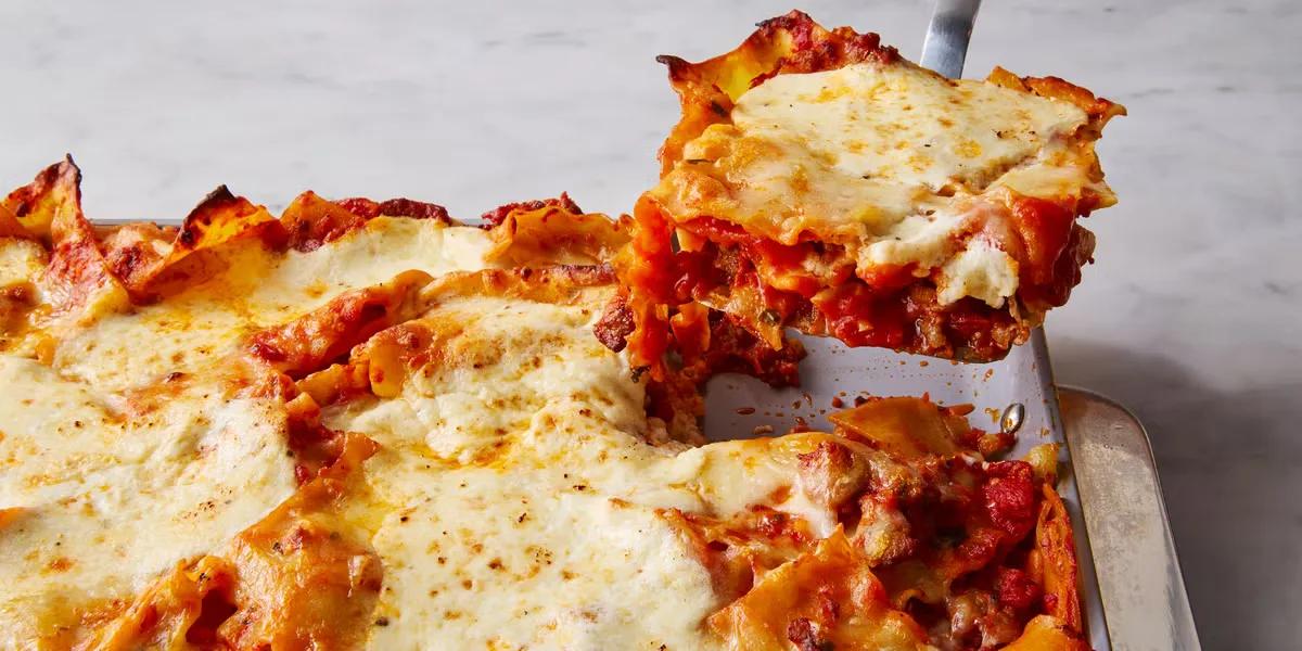 Golden bubbling sheet pan lasagna with broken noodles, melted mozzarella, and dollops of ricotta cheese