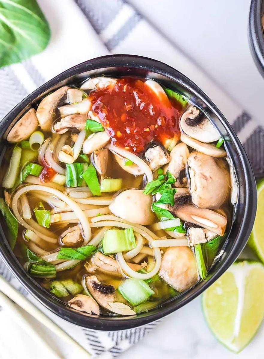 Bowl of chicken hot pot soup with noodles, bok choy and bean sprouts